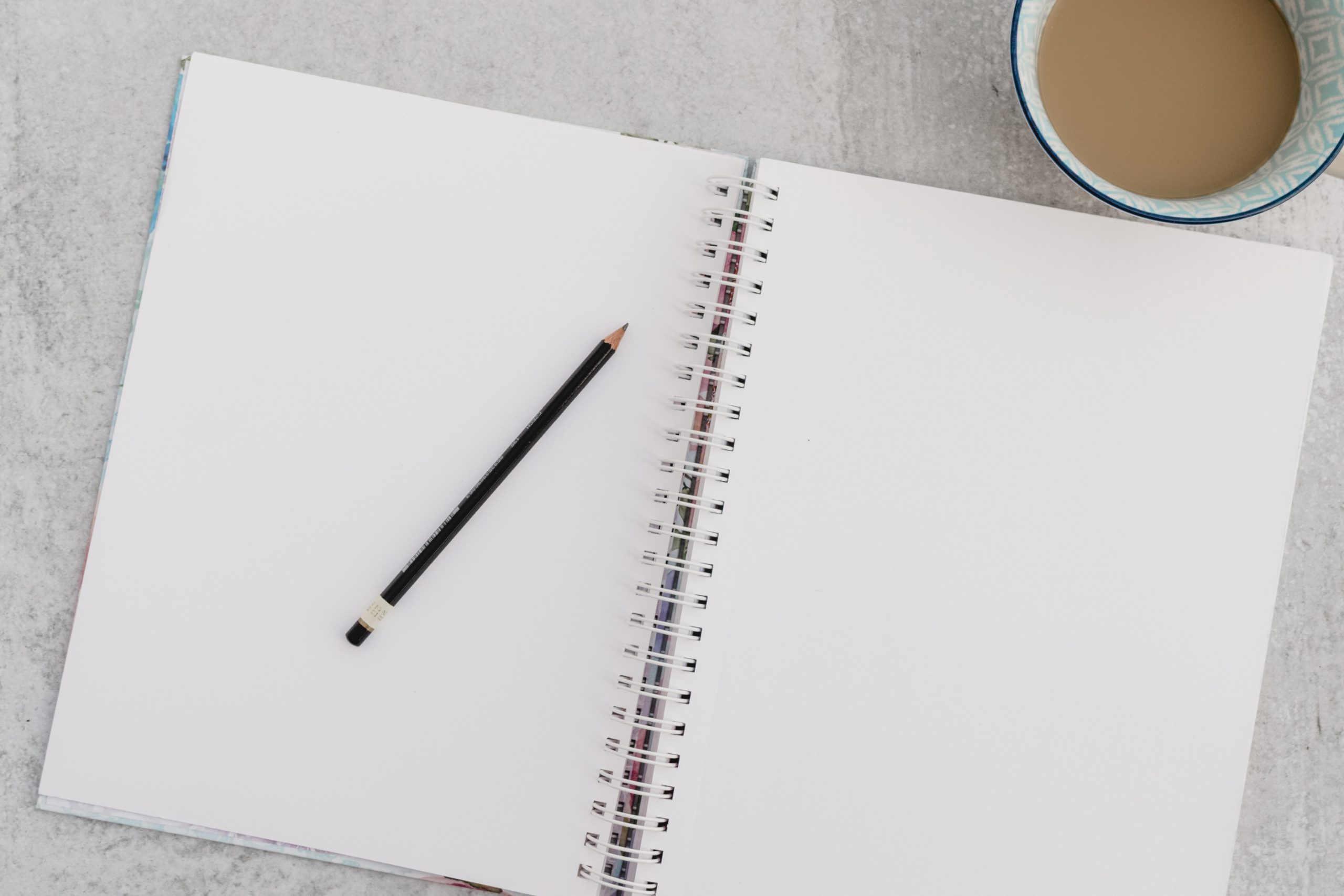 Pencil on an open journal with blank pages