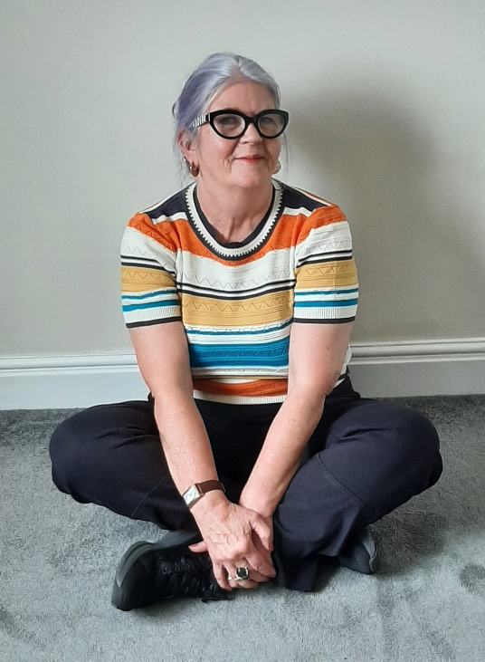 Hypnotherapist Lorraine McReight sitting crosslegged on the floor