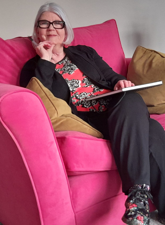 Hypnortherapist Lorraine McReight stiing on a pink chair at an Intensive Therapy Retreat