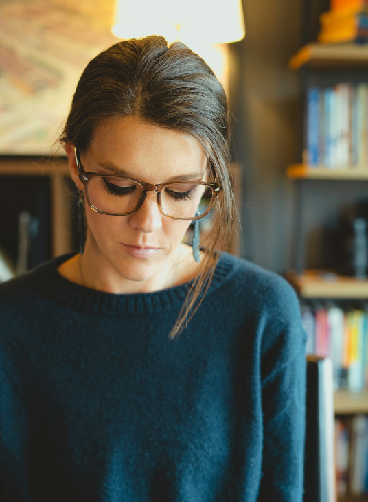 Woman in black jumper looking down
