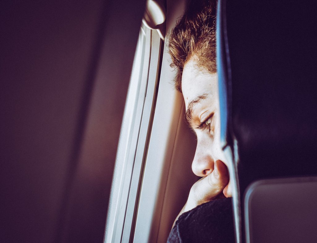 Anxious person looking out of a plane window