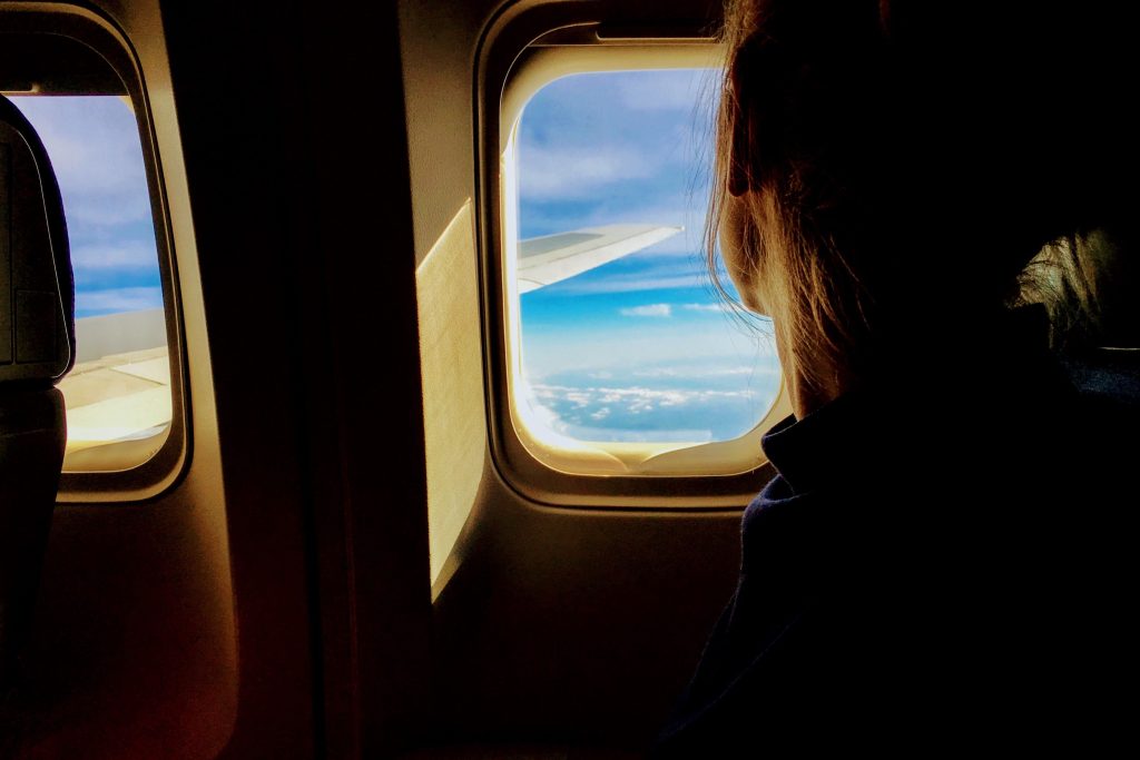 Woman looking anxiously out of the window of a plane
